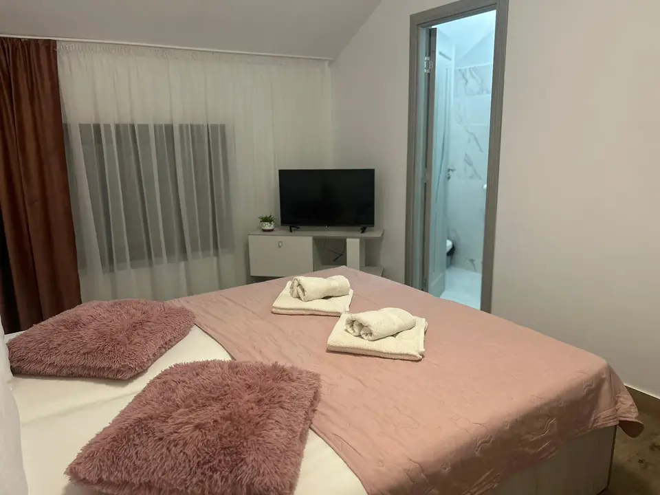 Cameră pentru invitați cu pat dublu și pernuțe roz