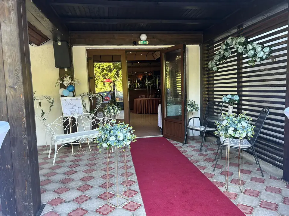 Intrarea în sală, cu covor roșu și flori albe